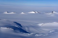 04D Small Mountains Pop Up From The Surrounding Glacier From Airplane Flying From Union Glacier Camp To Mount Vinson Base Camp